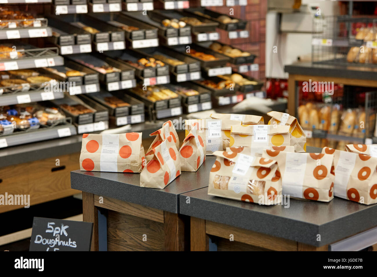 freshly made donuts in an instore bakery tesco supermarket Stock Photo