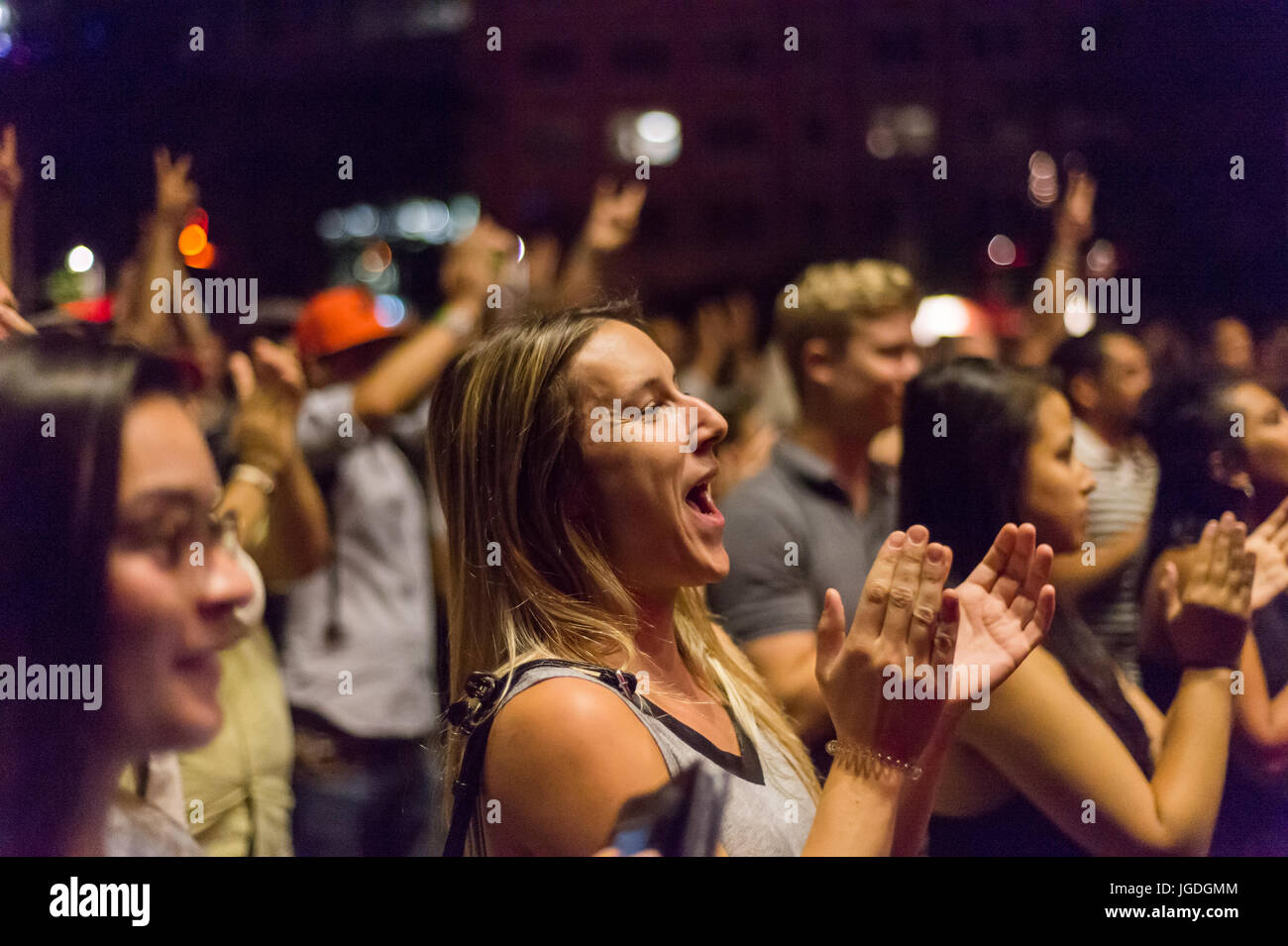 Montreal, 4 July 2017: Young woman clapping and smiling at the end of  'Ghost Town Blues Band' performance at Montreal Jazz Festival Stock Photo