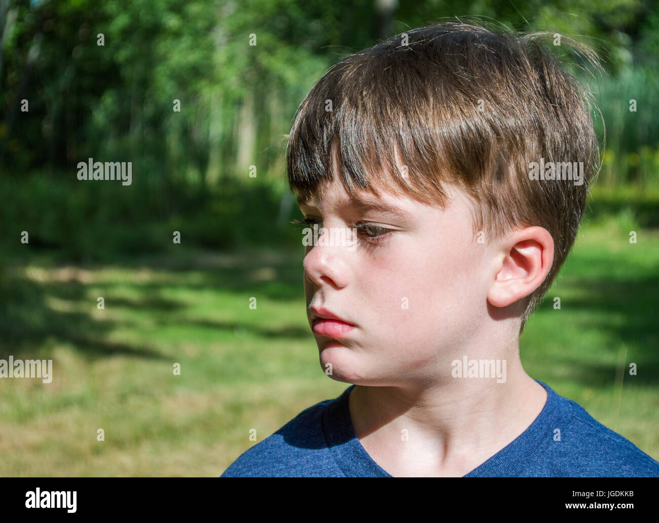side view close up of young caucasian boy looking pensive Stock Photo