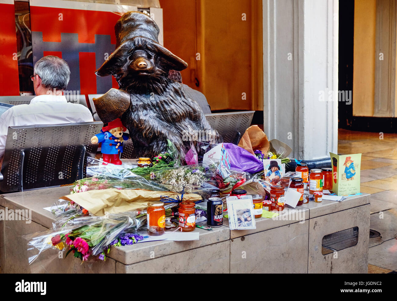 Jars of marmalade, cards and flowers laid at statue of Paddington Bear, at Paddington station, following the death of Michael Bond. Stock Photo