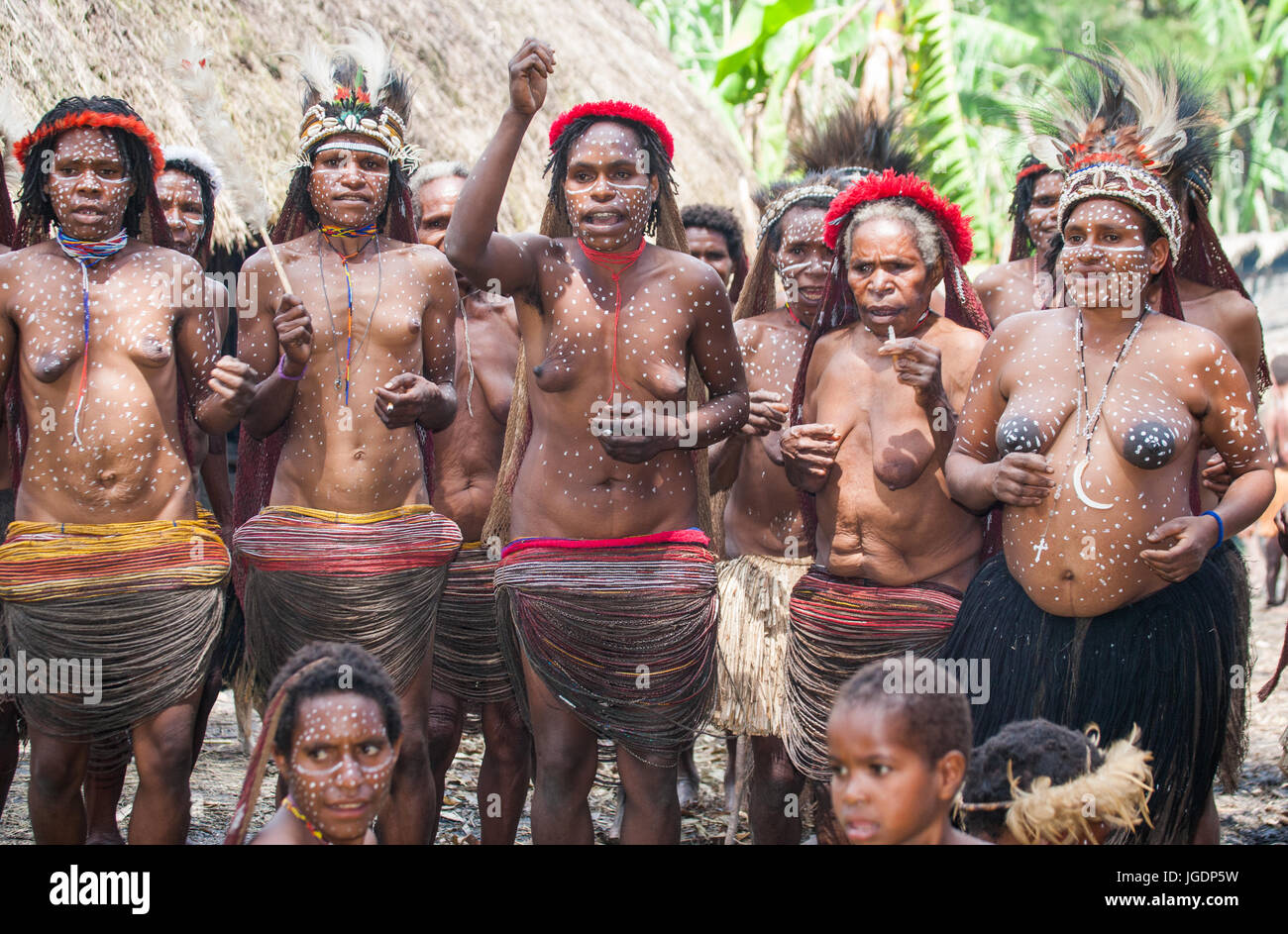 DANI VILLAGE, WAMENA, IRIAN JAYA, NEW GUINEA, INDONESIA – 15 MAY 2012: Women Dani tribe sing songs. Stock Photo