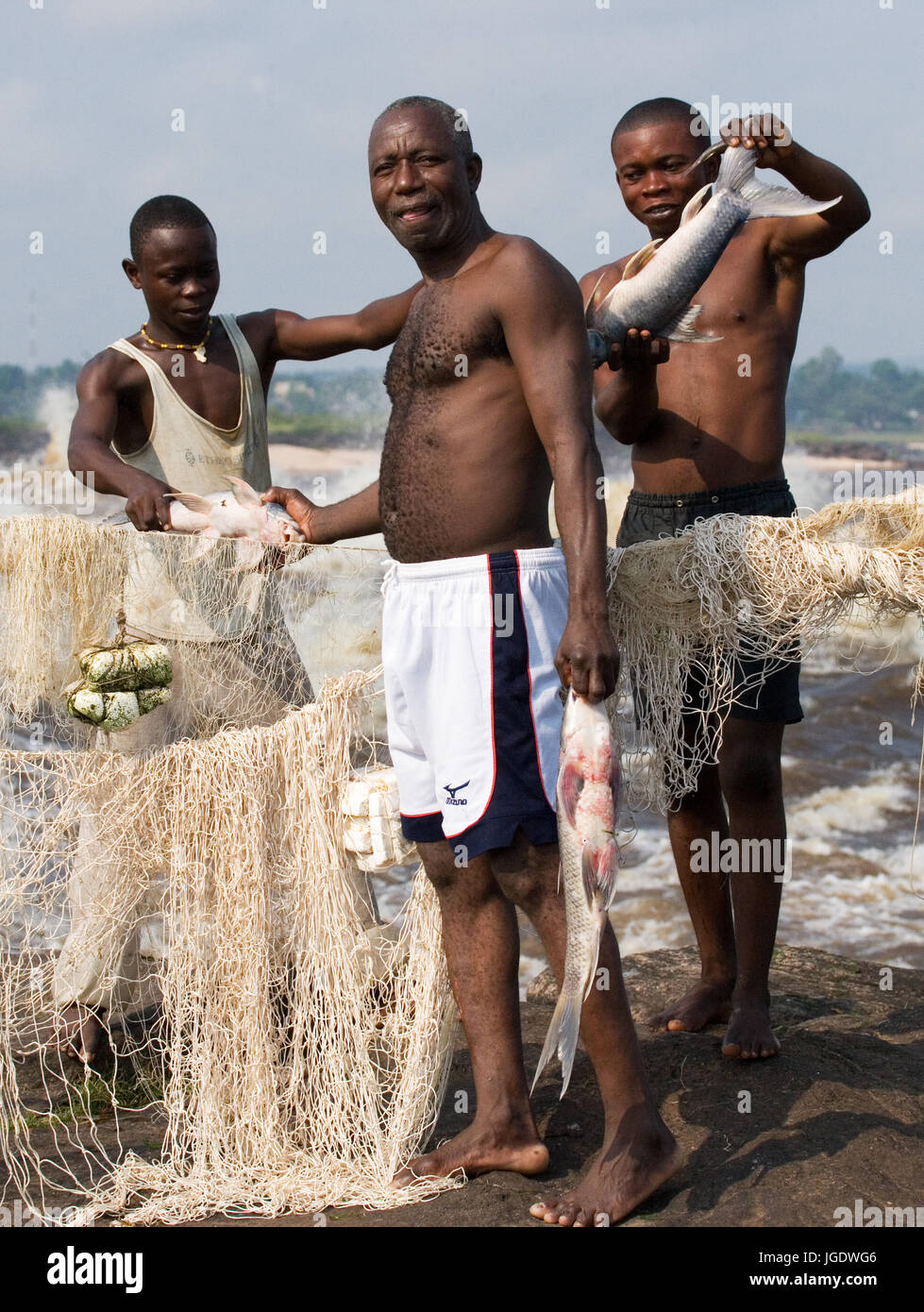 REPUBLIC OF CONGO, SUBURB OF BRAZZAVILLE - MAY 09, 2007: Fishermen with fish near Brazzaville. The rapids of the Congo River. Stock Photo