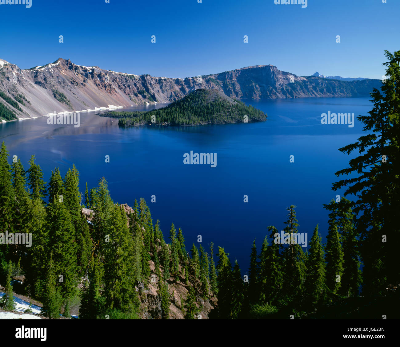 USA, Oregon, Crater Lake National Park, Wizard Island and Crater Lake with a grove of mountain hemlock on the south rim descending towards the lake. Stock Photo
