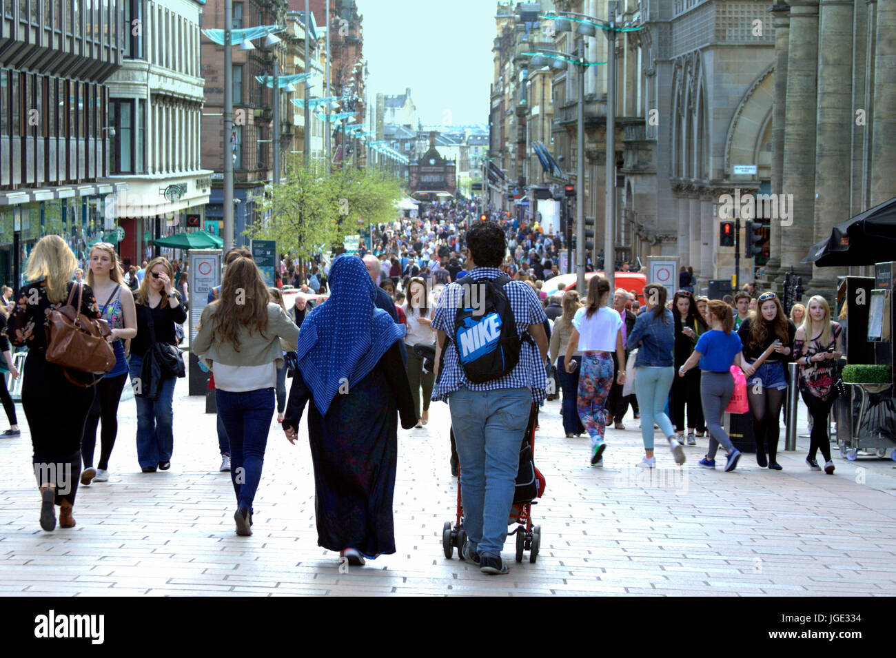 Glasgow street Buchanan Street shoppers hijab wearing Muslim with family buggy pram sunny day Stock Photo