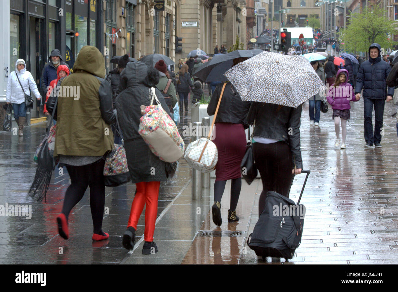 Glasgow street Buchanan Street shoppers woman crossing road with umbrella in rain Stock Photo