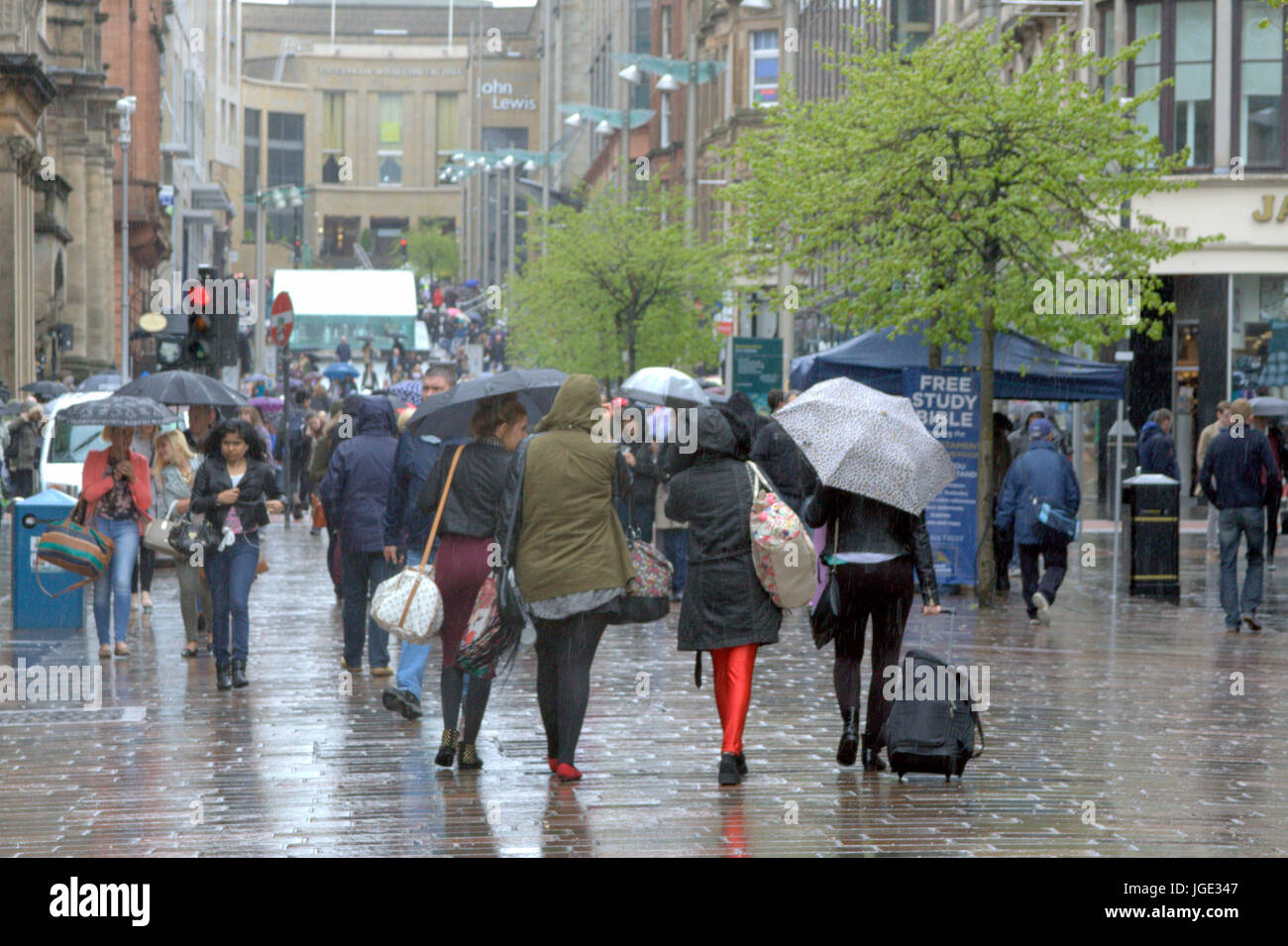 Glasgow street Buchanan Street shoppers woman crossing road with umbrella in rain Stock Photo