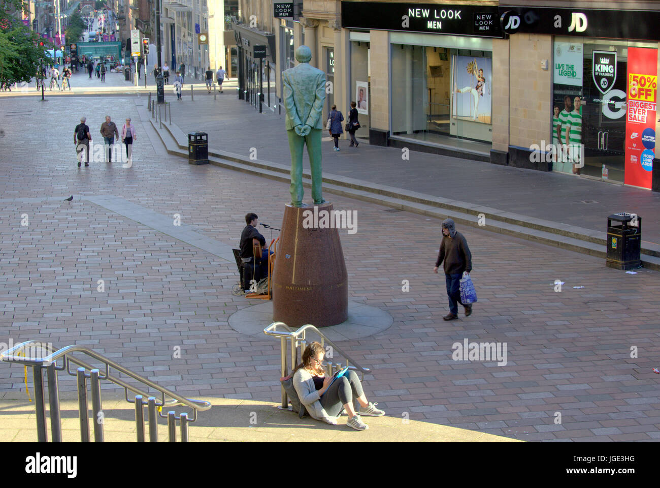 Glasgow street student reads book on the Sauchiehall street steps near the Donald Dewar statue Stock Photo