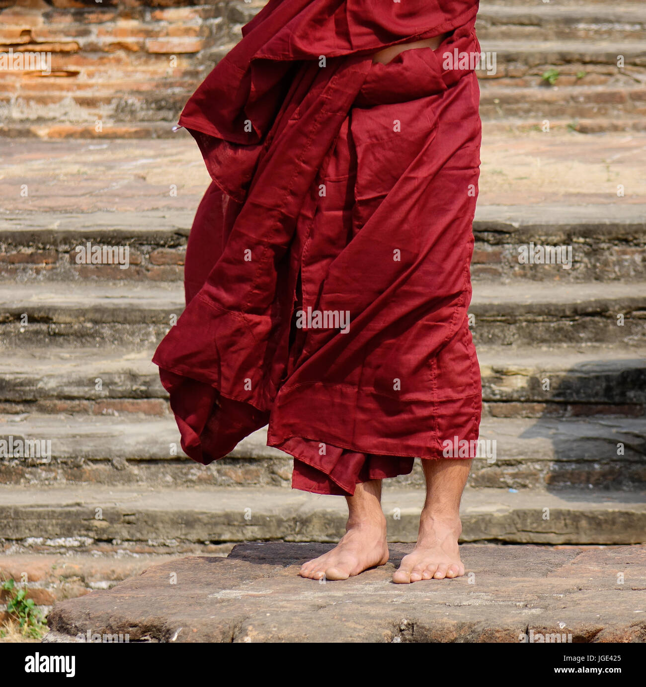 A Buddhist monk in the red robe standing at the Buddhist pagoda Stock