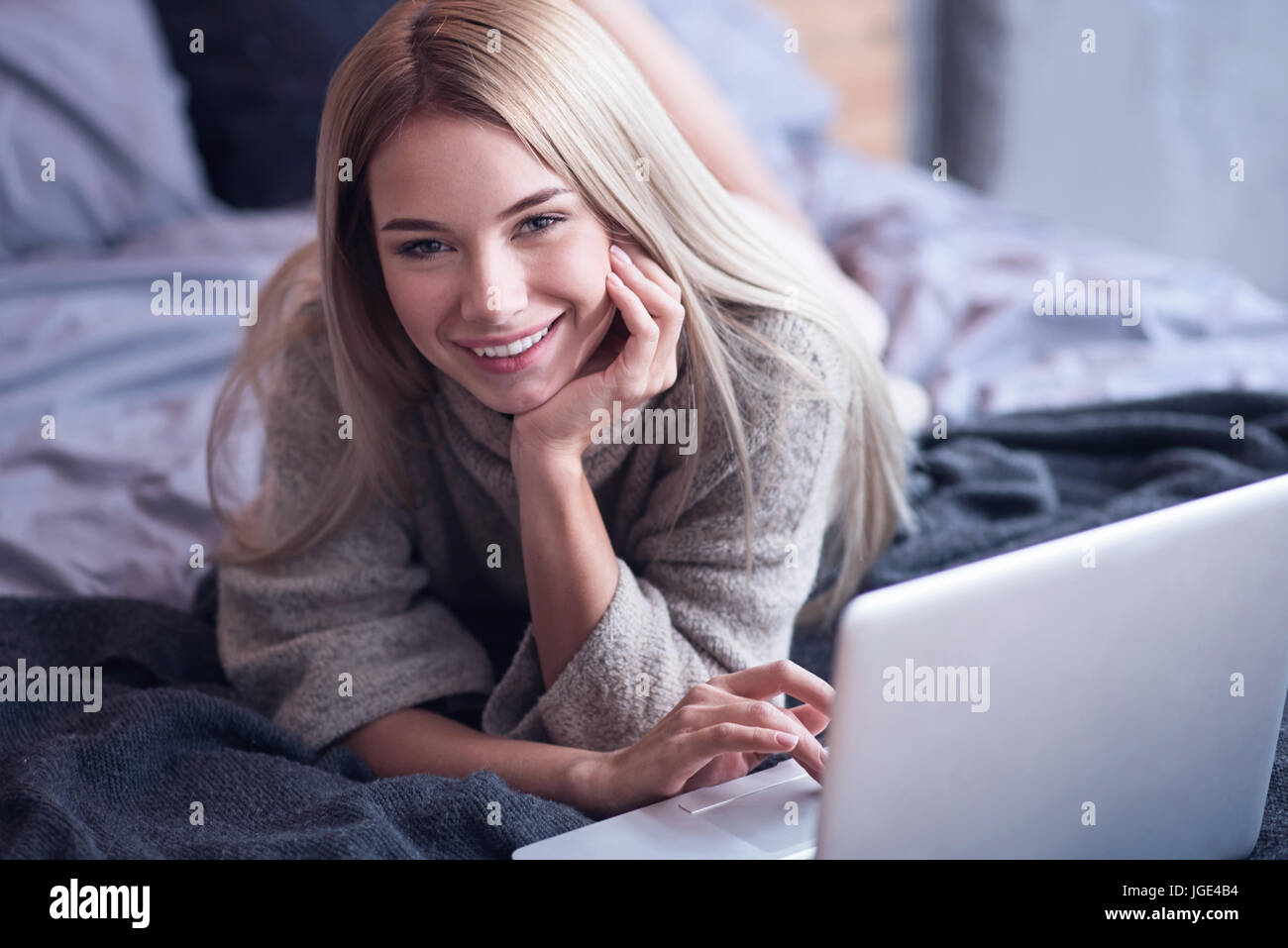 Cheerful young woman enjoying freelance work at home Stock Photo
