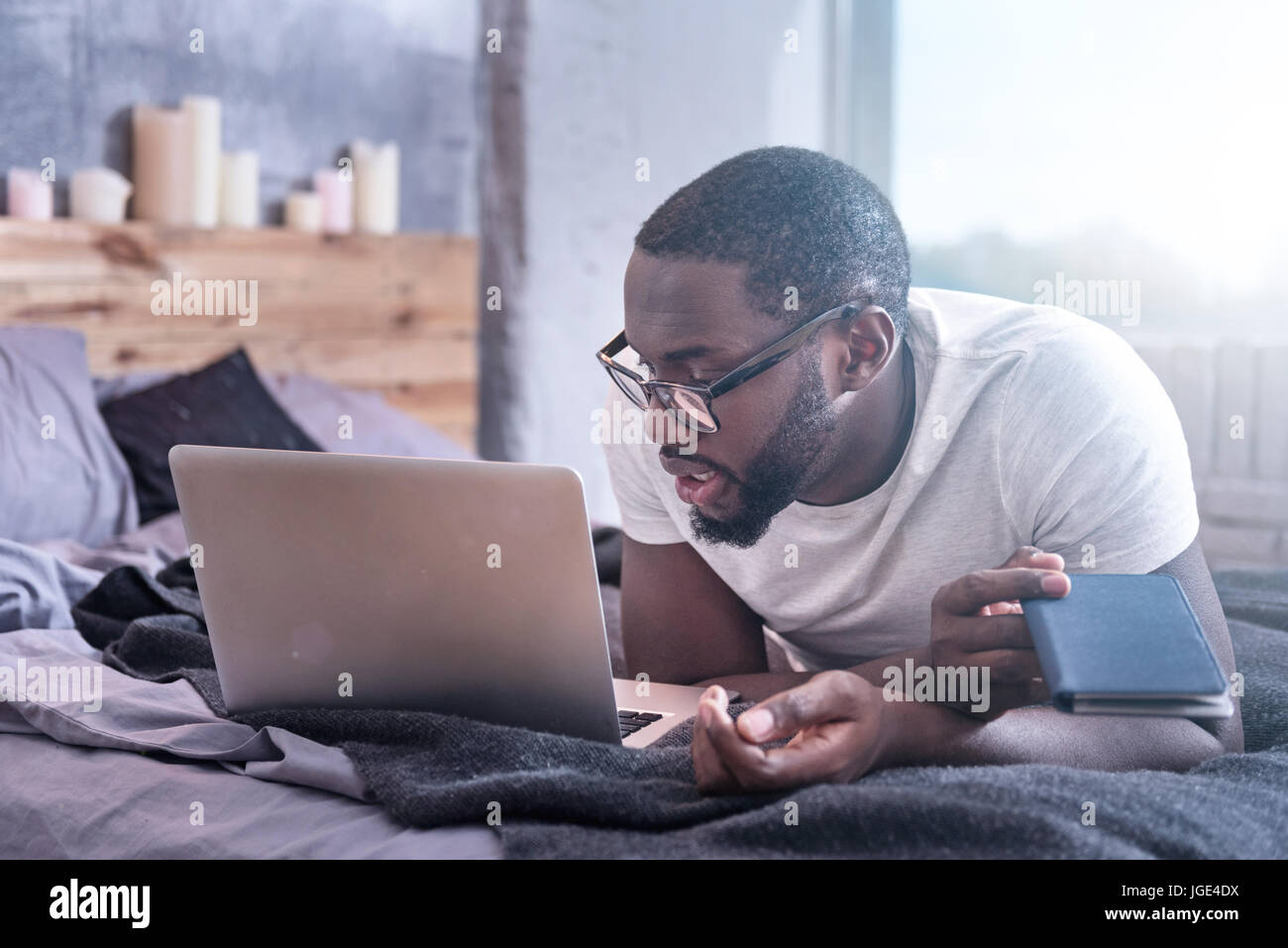 Enthusiastic young African American using laptop at home Stock Photo