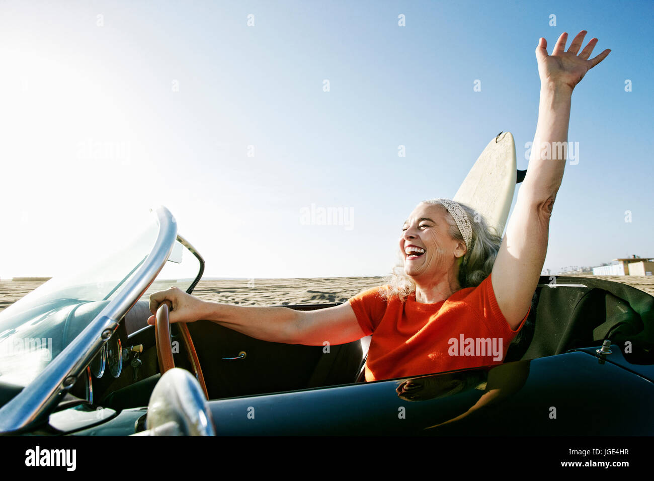 Older Caucasian woman in convertible car with surfboard on beach Stock ...