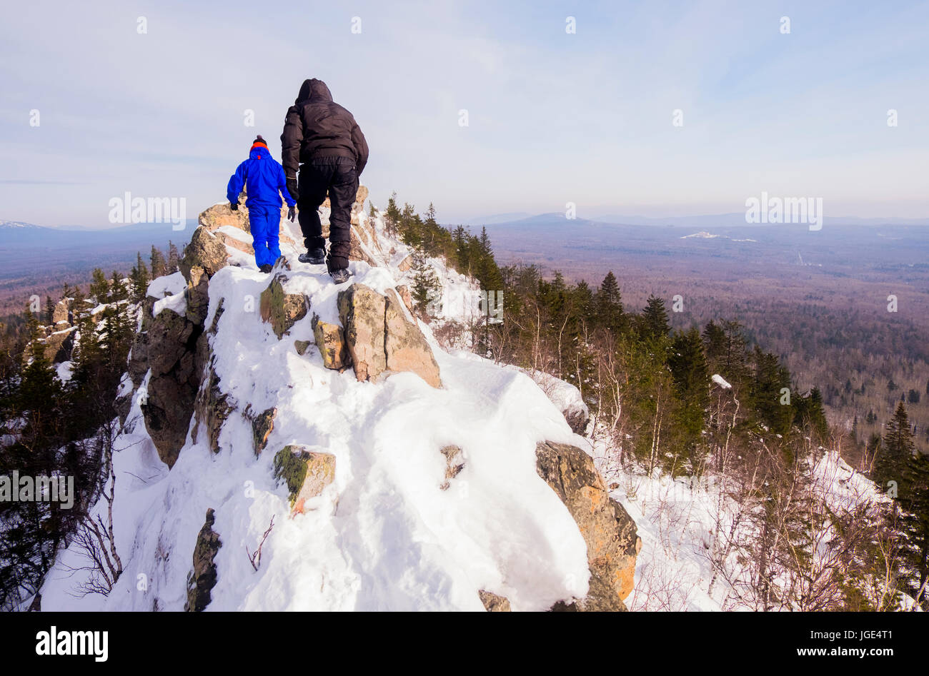 Caucasian men hiking on mountain in winter Stock Photo