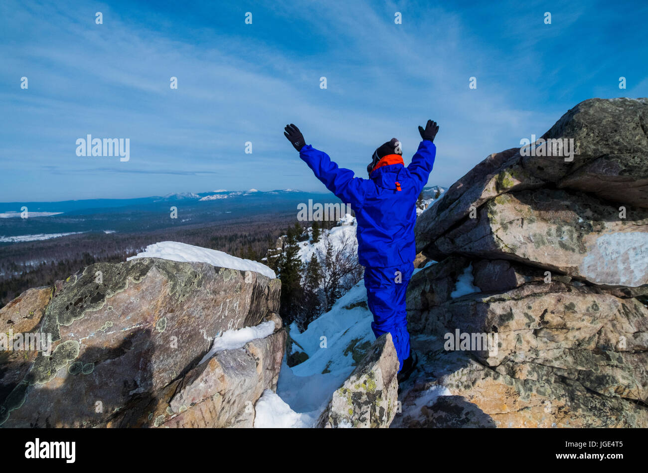 Caucasian man celebrating on mountain top in winter Stock Photo