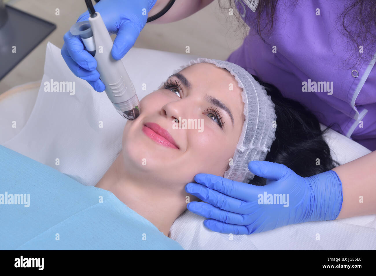Young beautiful woman gets professional rejuvenation facial skin treatment in a professional beauty clinic Stock Photo