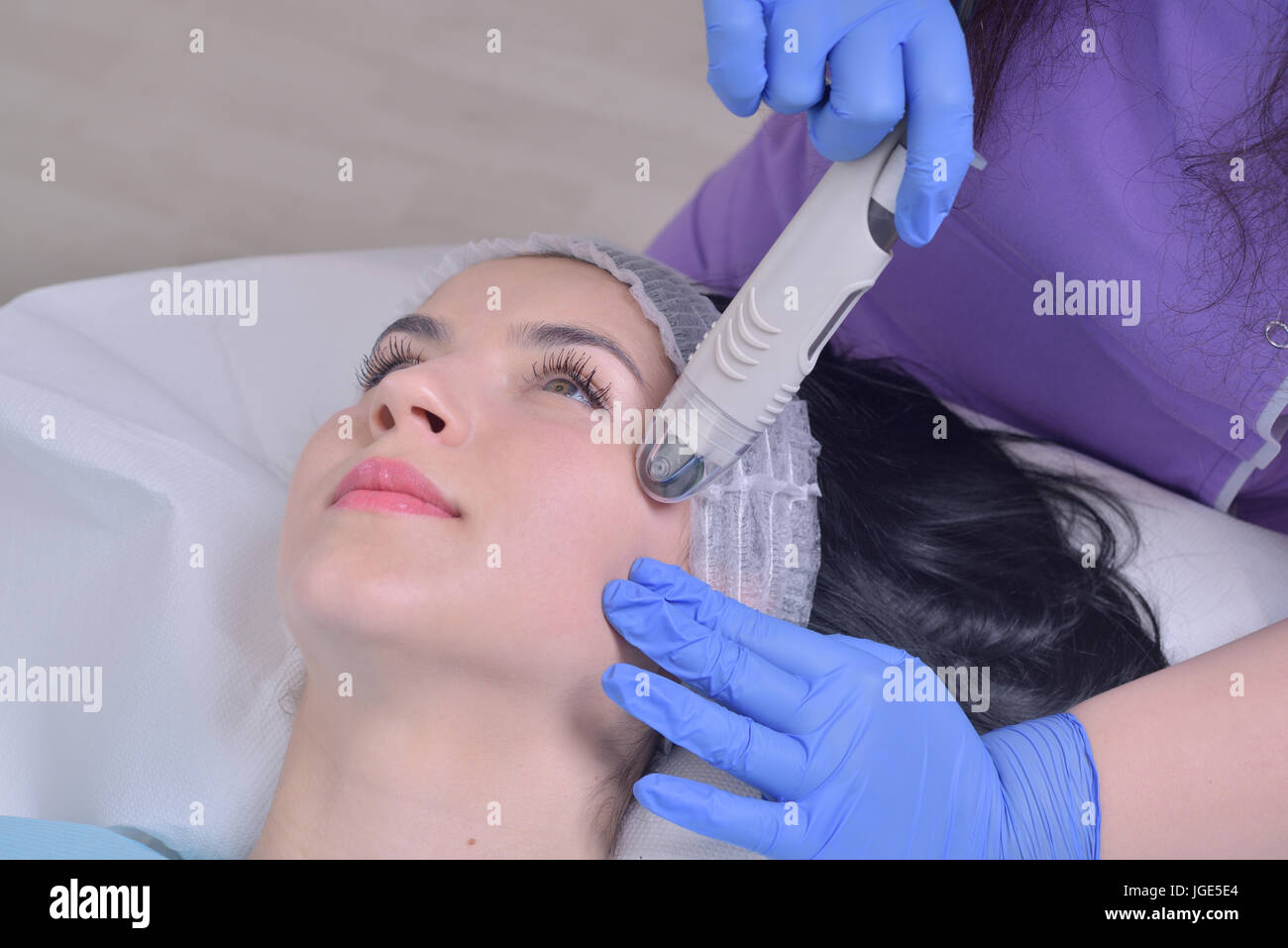 Young beautiful woman gets professional facial skin treatment in a professional beauty clinic Stock Photo