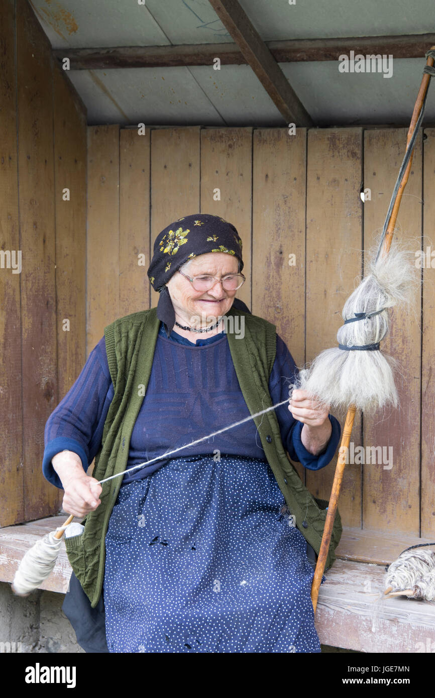 a woman spinning wool with a traditional method of the Maramures region
