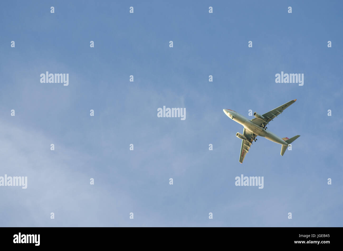 Airplane in blue sky Stock Photo - Alamy