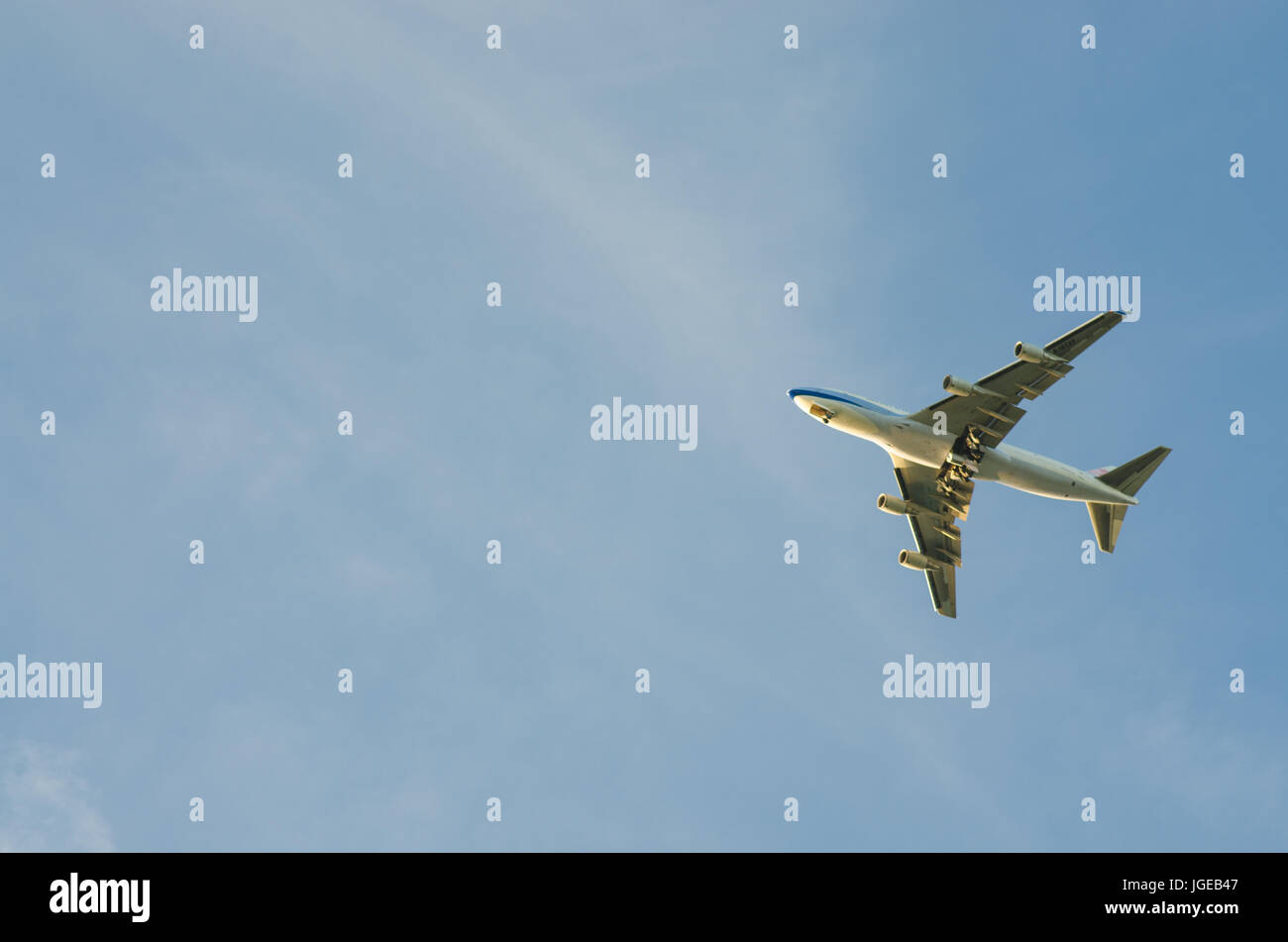 Airplane in blue sky Stock Photo - Alamy