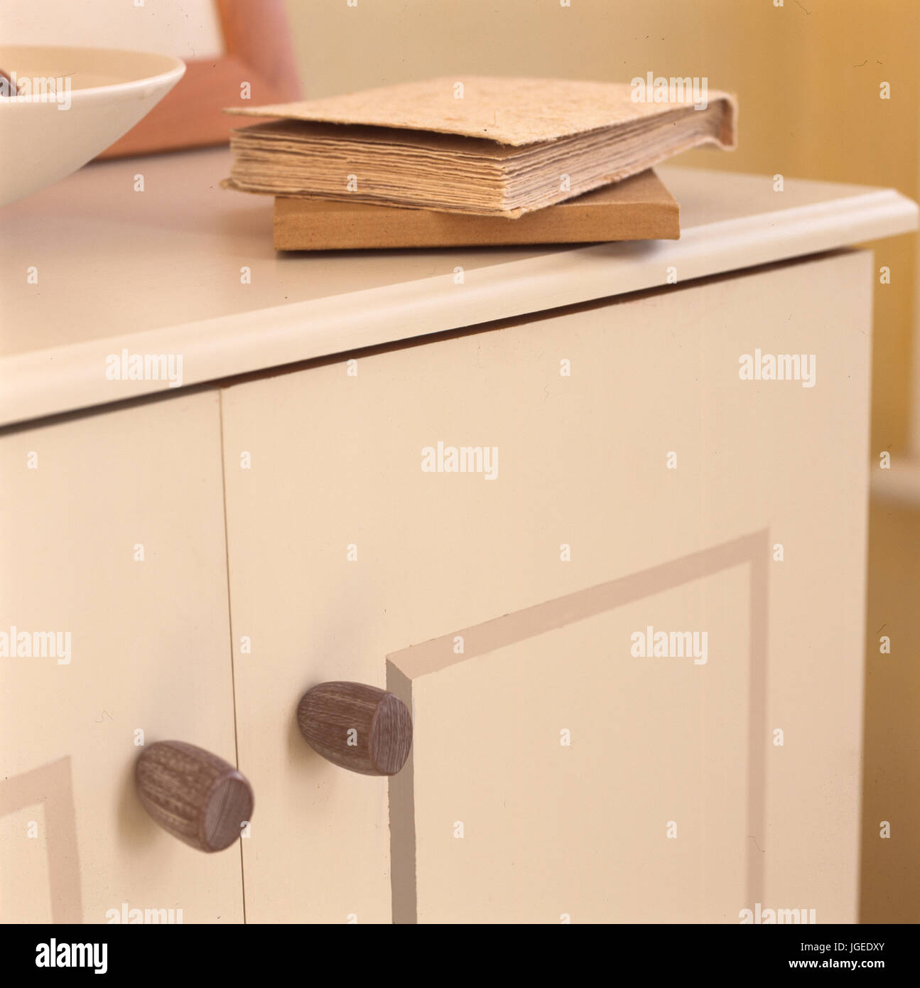 Covered notebooks on cream painted cupboard Stock Photo