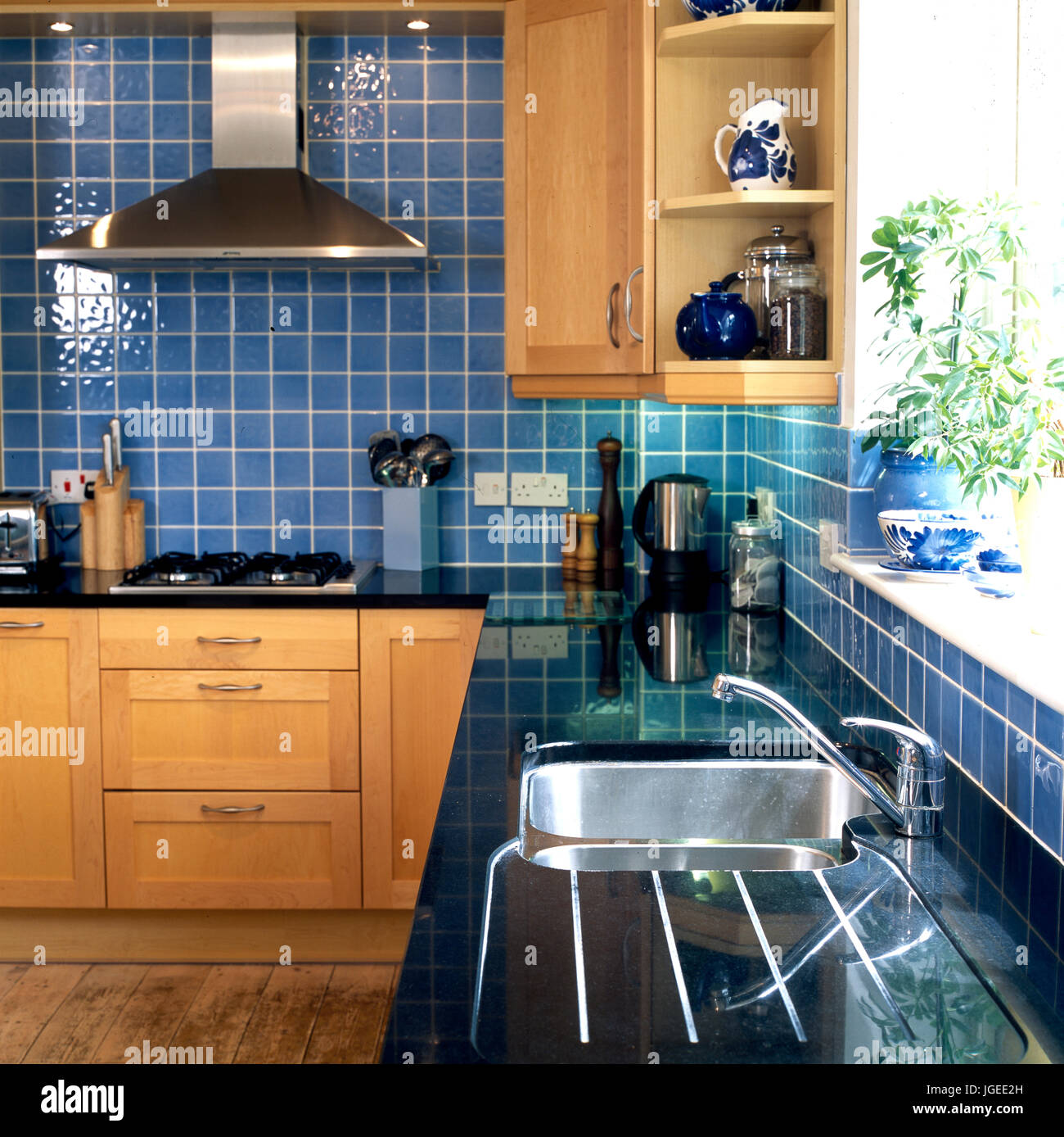 Blue tiled kitchen with black counter top Stock Photo