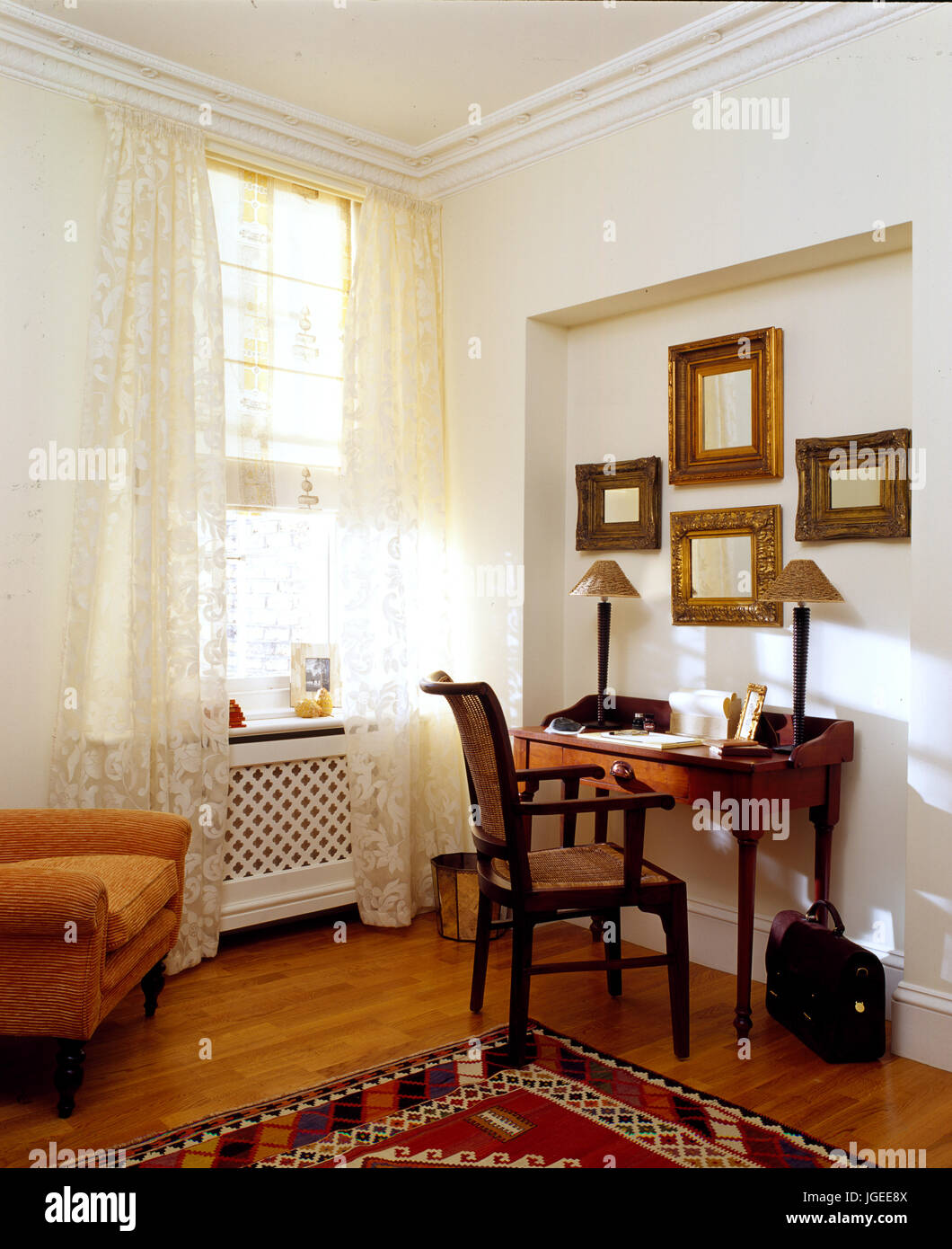 Mahogany writing table in corner of sitting room Stock Photo