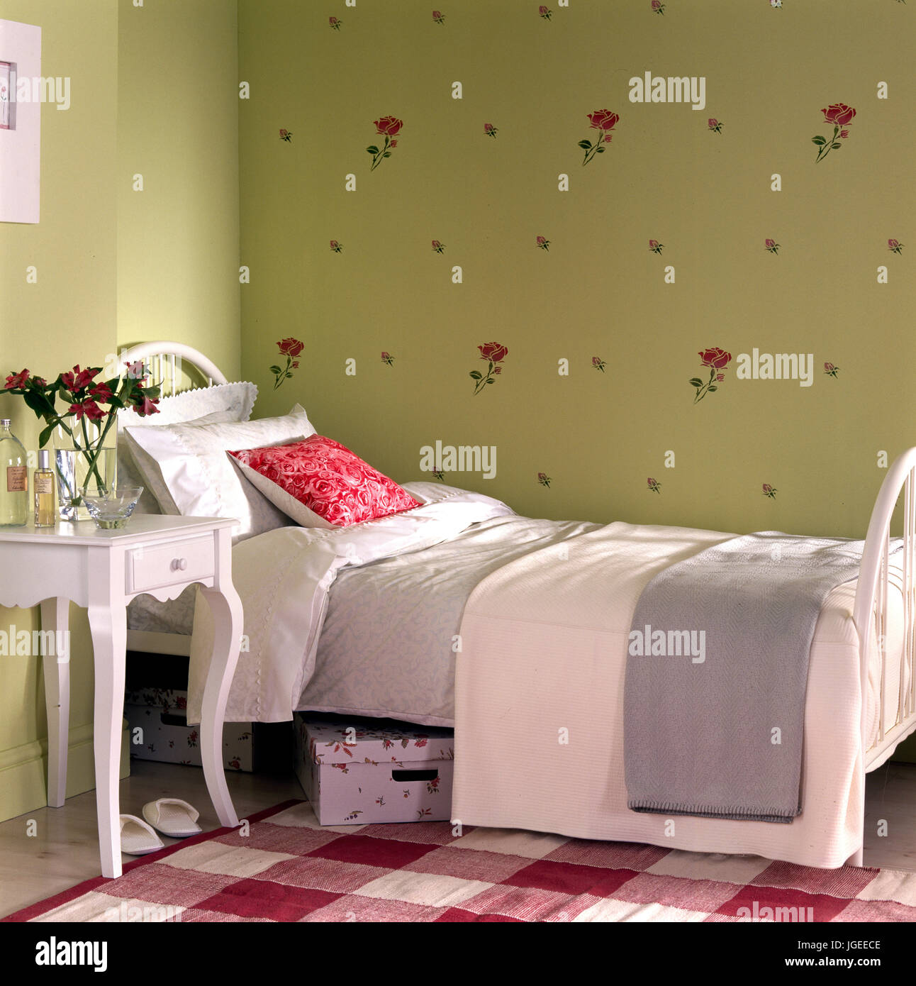 Traditonal girls single bedroom with white painted bed and rose patterned Stock Photo