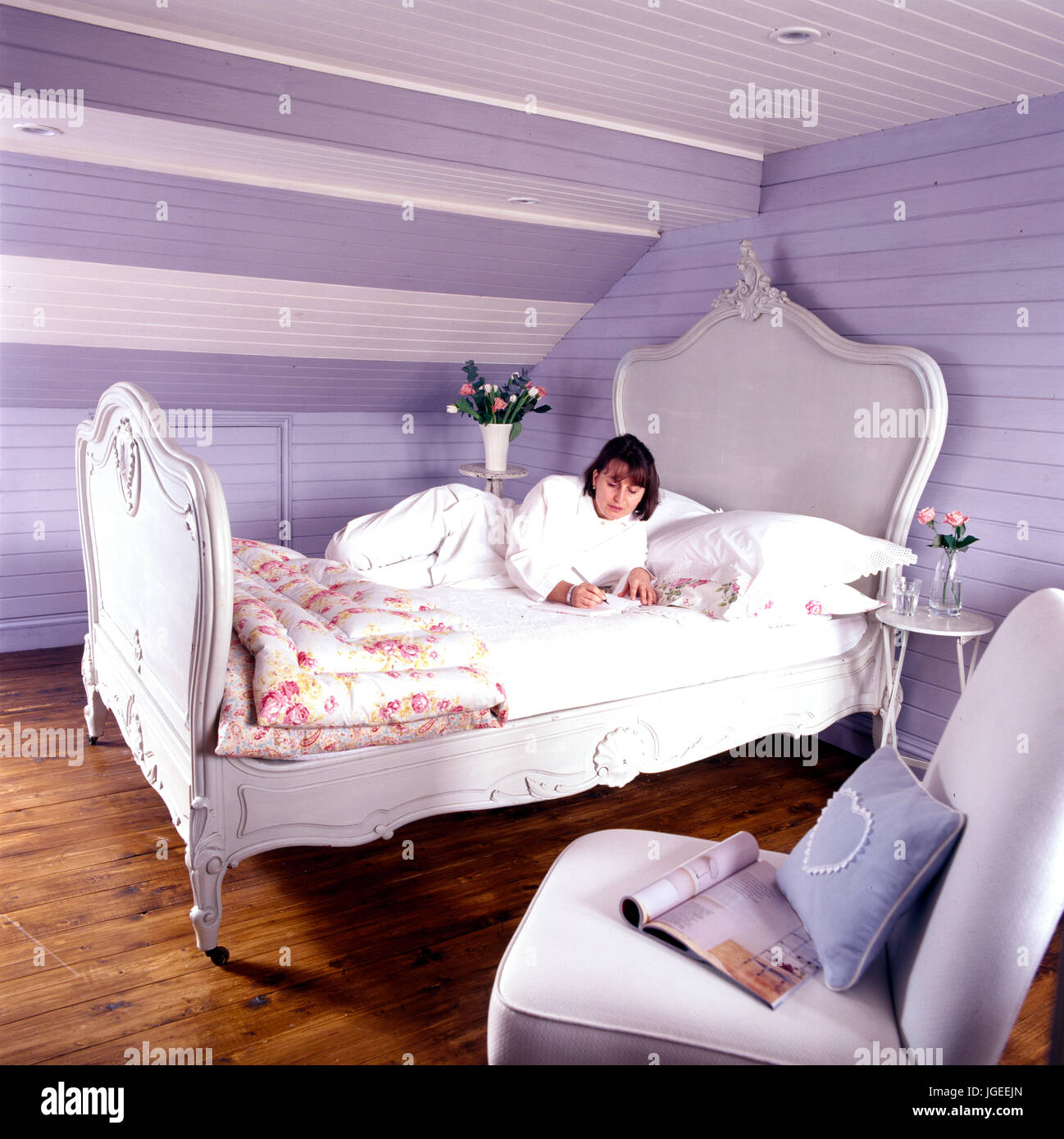 Woman writing her diary in French style bed Stock Photo