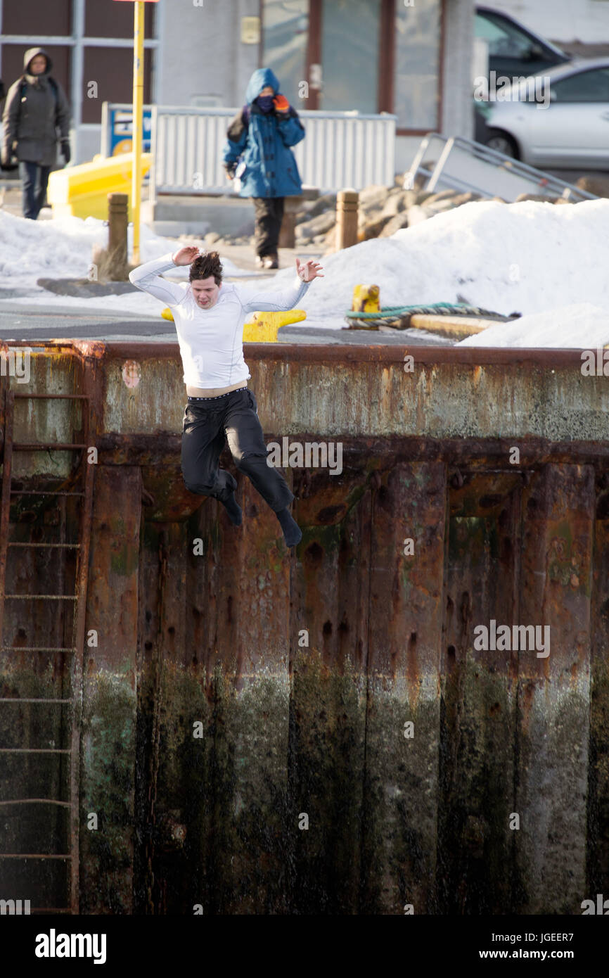 Reykjavik harbour, a man jumps into the freezing water Stock Photo