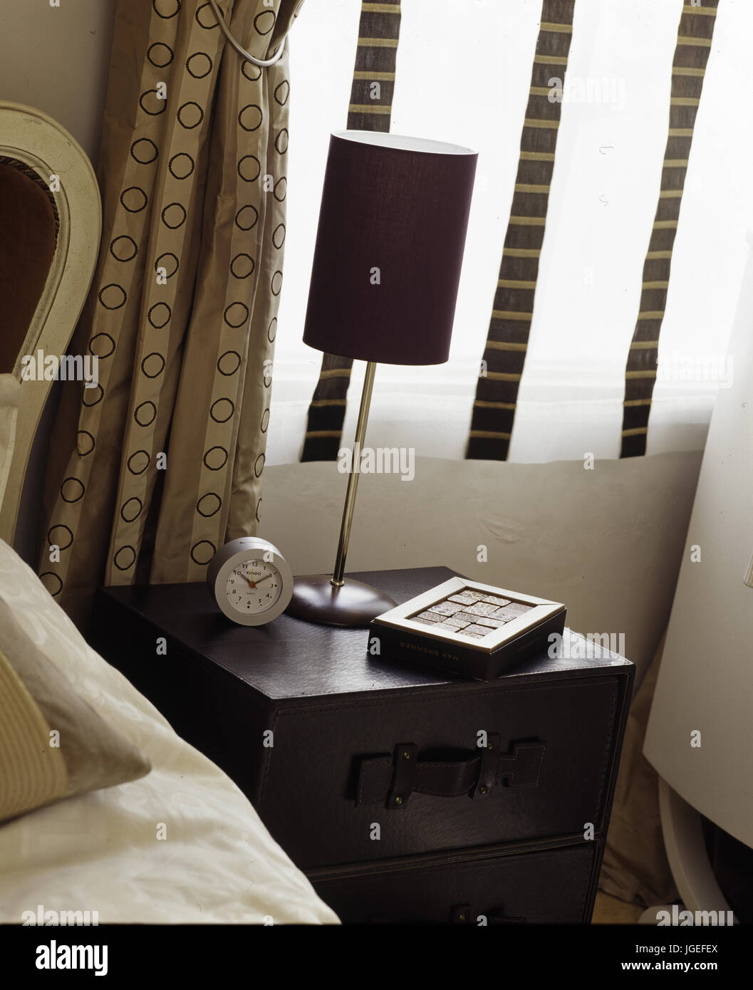 Bedside table with lamp and clock Stock Photo