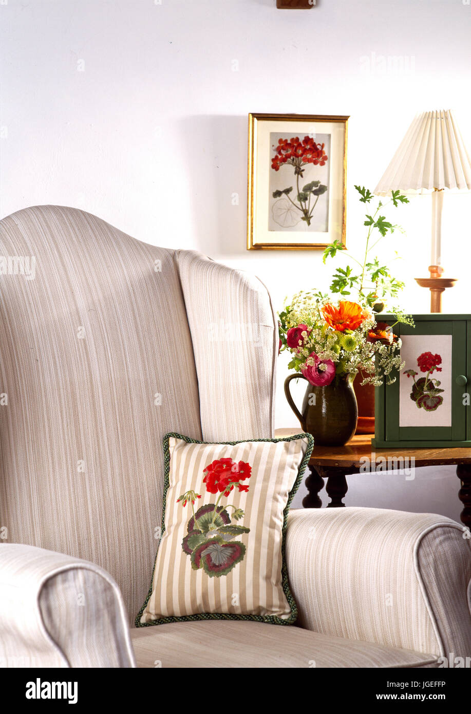 Cushion with geranium design on easy chair in corner of livingroom Stock Photo
