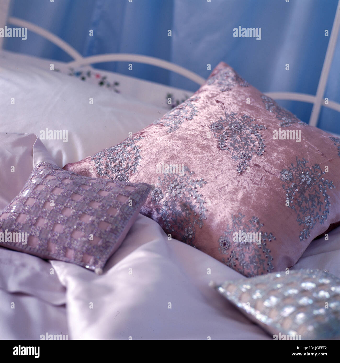 Pretty beaded pink cushions on satin sheets Stock Photo Alamy