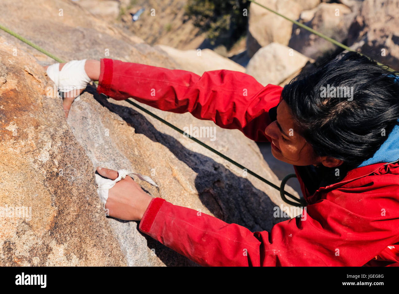South asian young woman rock climbing in the desert Stock Photo - Alamy