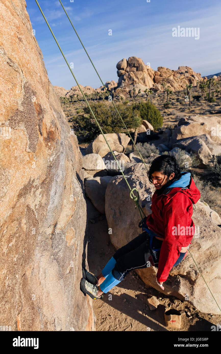 South asian young woman rock climbing in the desert Stock Photo - Alamy