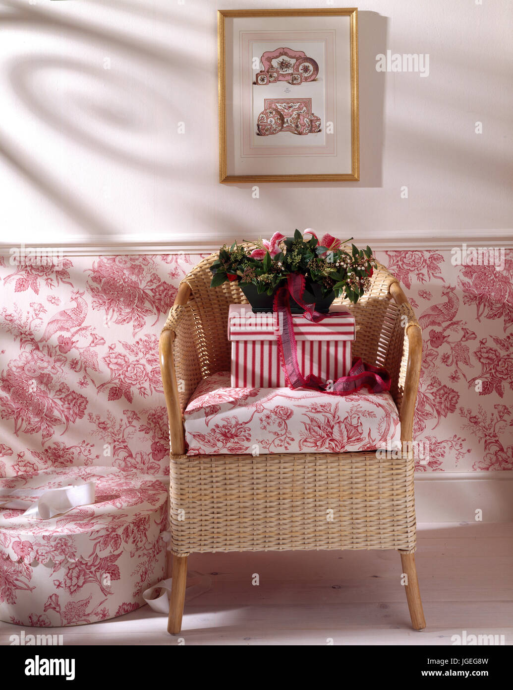 Cane chair with fabric cushion to match below dado wall covering Stock Photo