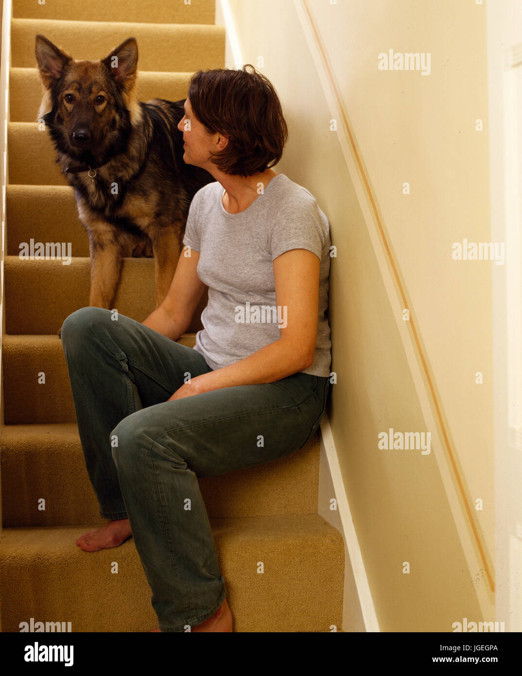 Woman talking to her dog on stairs Stock Photo
