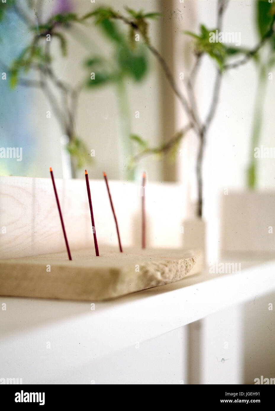 Joss sticks burning in stone holder Stock Photo - Alamy