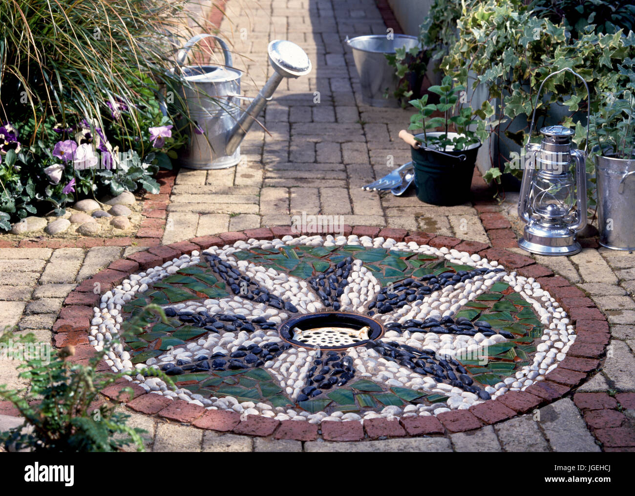 DIY Water feature in garden: Mosaic edging around small circular pool Stock Photo