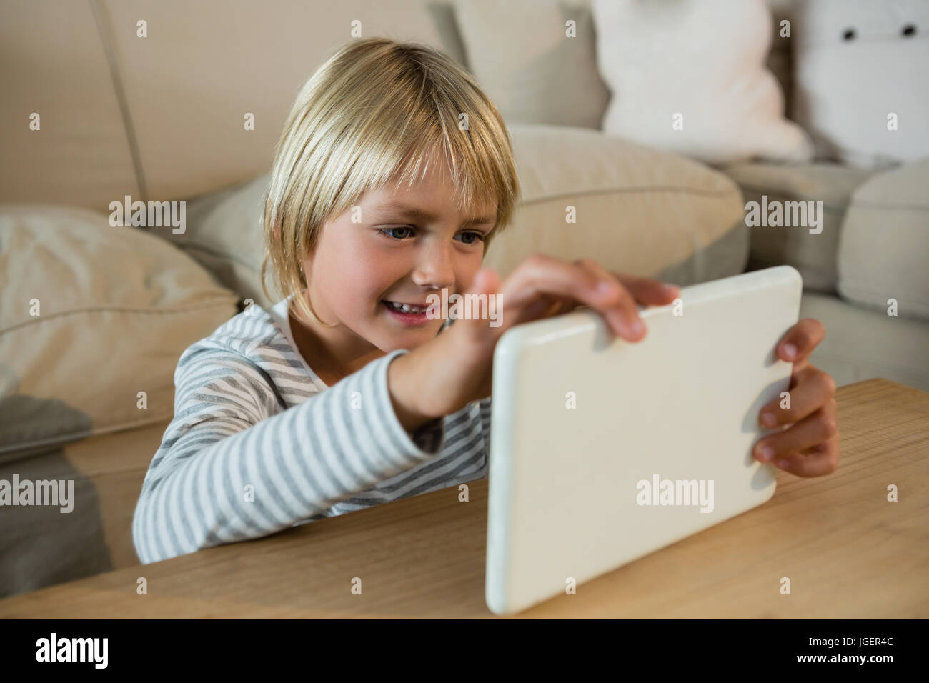 Boy using digital tablet in the living room at home Stock Photo - Alamy