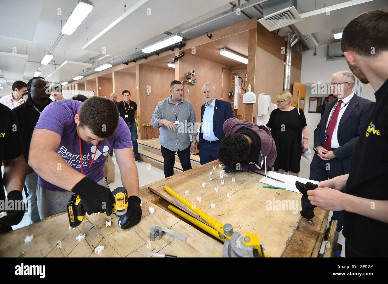 Labour leader Jeremy Corbyn (centre right) watches plumbing students