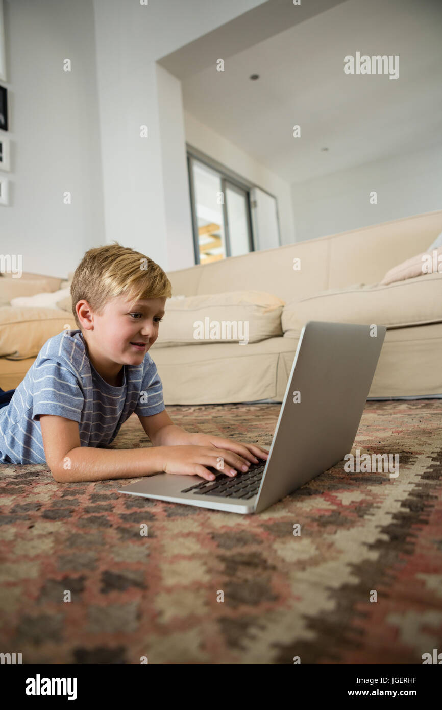 Boy using laptop in the living room at home Stock Photo - Alamy