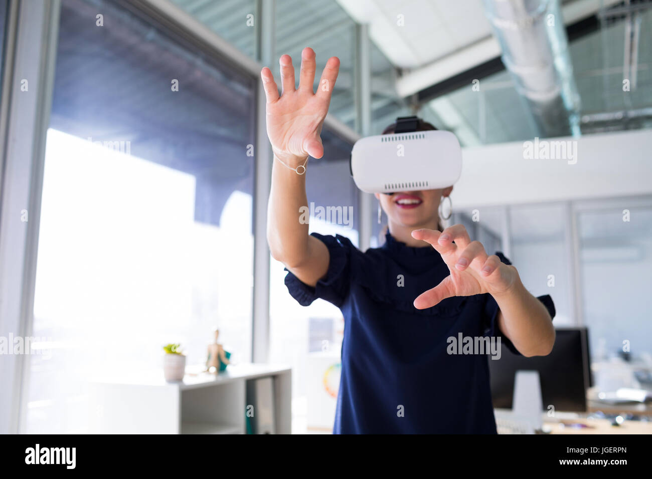 Female executive using virtual reality headset in office Stock Photo ...