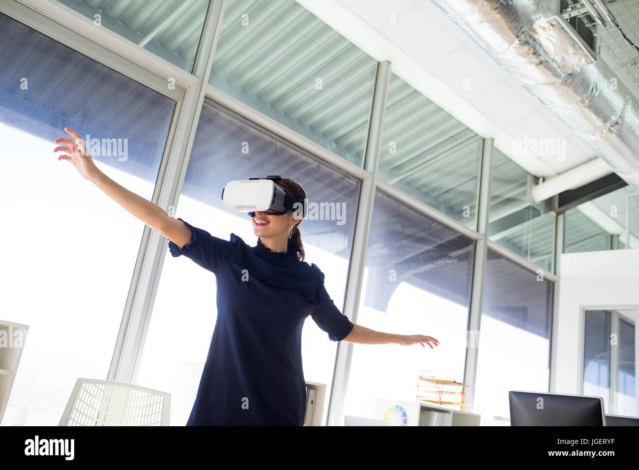 Female executive using virtual reality headset in office Stock Photo ...