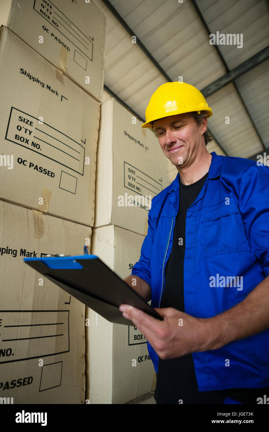 Smiling worker writing on clipboard in olives factory Stock Photo - Alamy