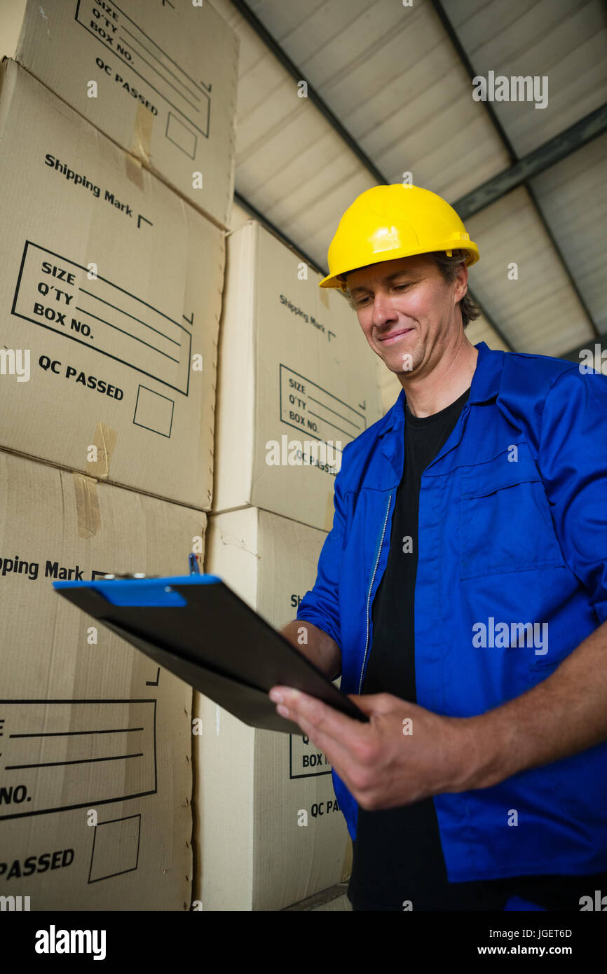 Smiling worker writing on clipboard in olives factory Stock Photo - Alamy