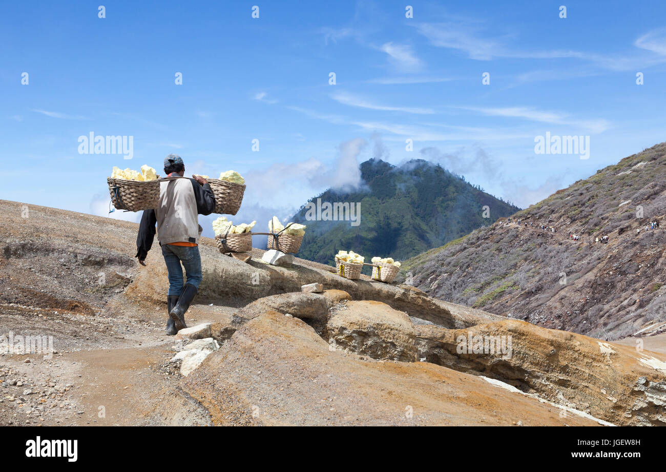 Workers Carrying Rocks Workers carrying baskets of Sulphur rock from volcano Stock Photo - Alamy