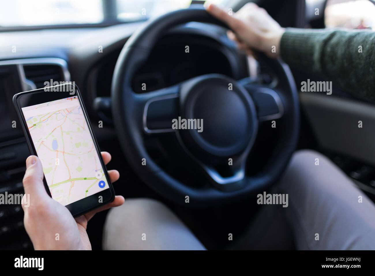 Cropped image of man using smartphone while driving car Stock Photo
