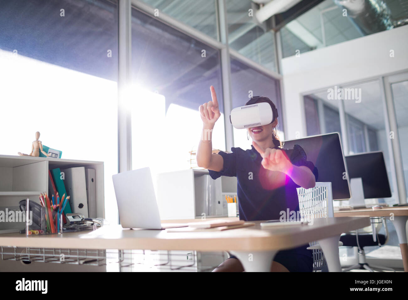Female executive using virtual reality headset in office Stock Photo ...