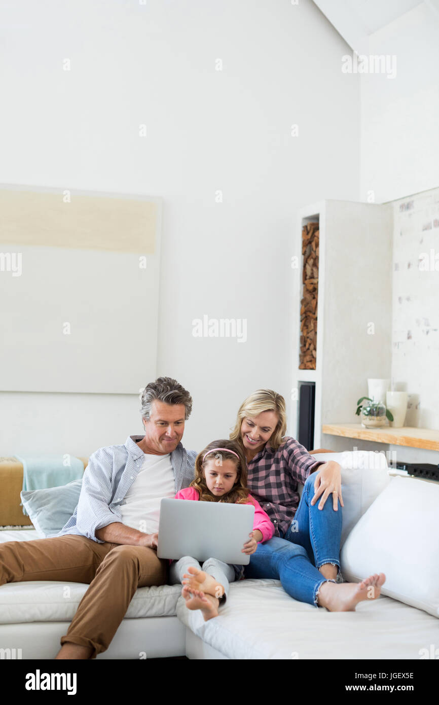 Family using laptop together in living room at home Stock Photo - Alamy