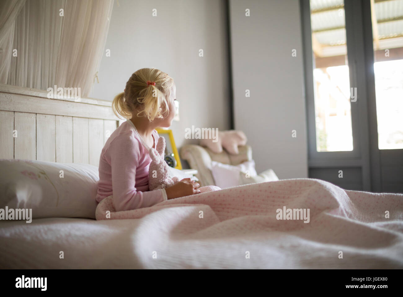 Thoughtful girl relaxing on bed in the bedroom at home Stock Photo