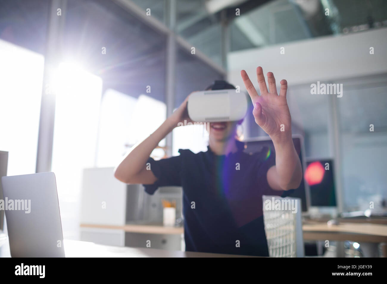 Female executive using virtual reality headset in office Stock Photo ...